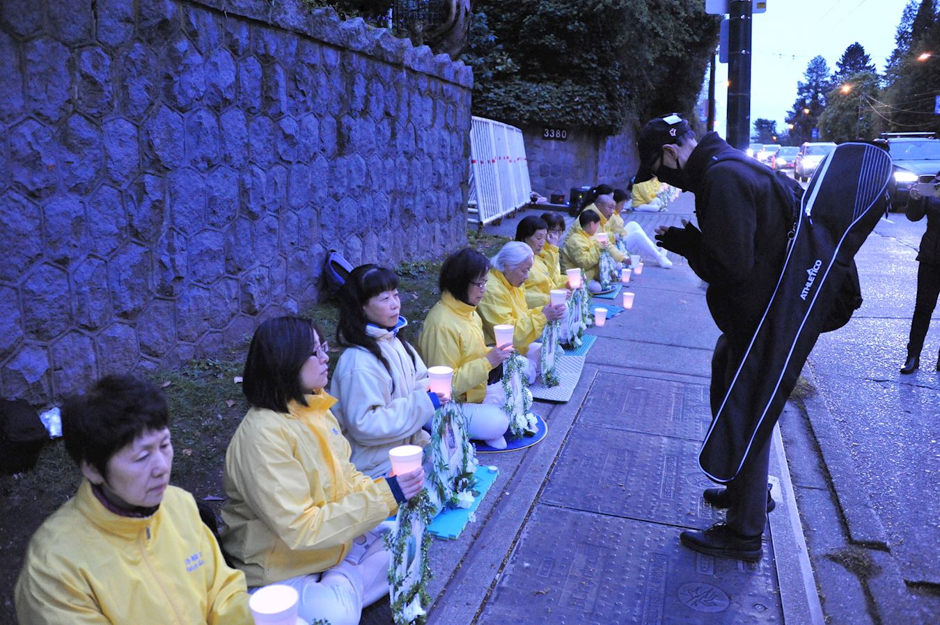 '图11:二十四日晚,大温居民约翰特意赶到现场向每一位法轮功学员鞠躬致敬。'