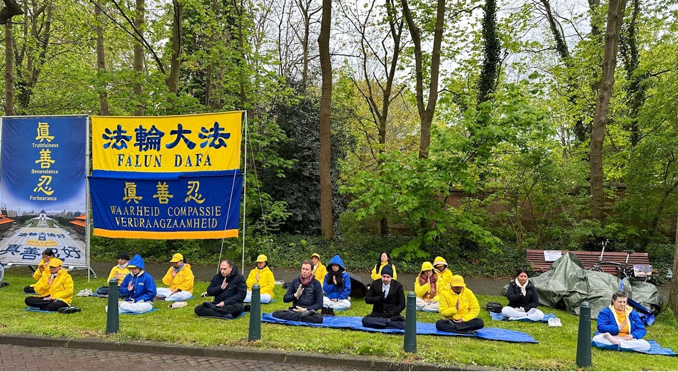 '图1~2:荷兰法轮功学员及来自墨西哥、加拿大和阿鲁巴岛的学员在海牙中国驻荷兰大使馆对面的街道举行集会'