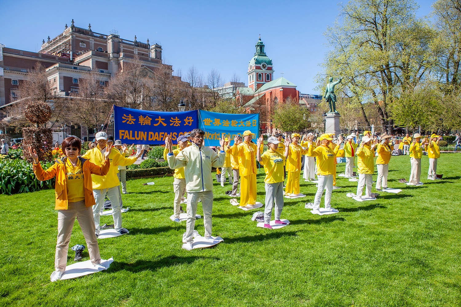 图1~2:二零二四年五月十一日,法轮功学员在斯德哥尔摩皇家花园庆祝世界法轮大法日,学员们举行集体炼功,展示五套功法向市民传递大法的美好。