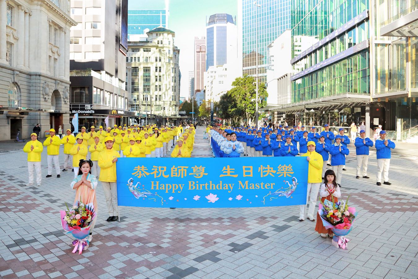 '图1:二零二四年五月十一日,新西兰法轮功学员在奥克兰市中心伊丽莎白(Elizabeth Square)广场庆祝世界法轮大法日,恭祝伟大的师尊生日快乐。'