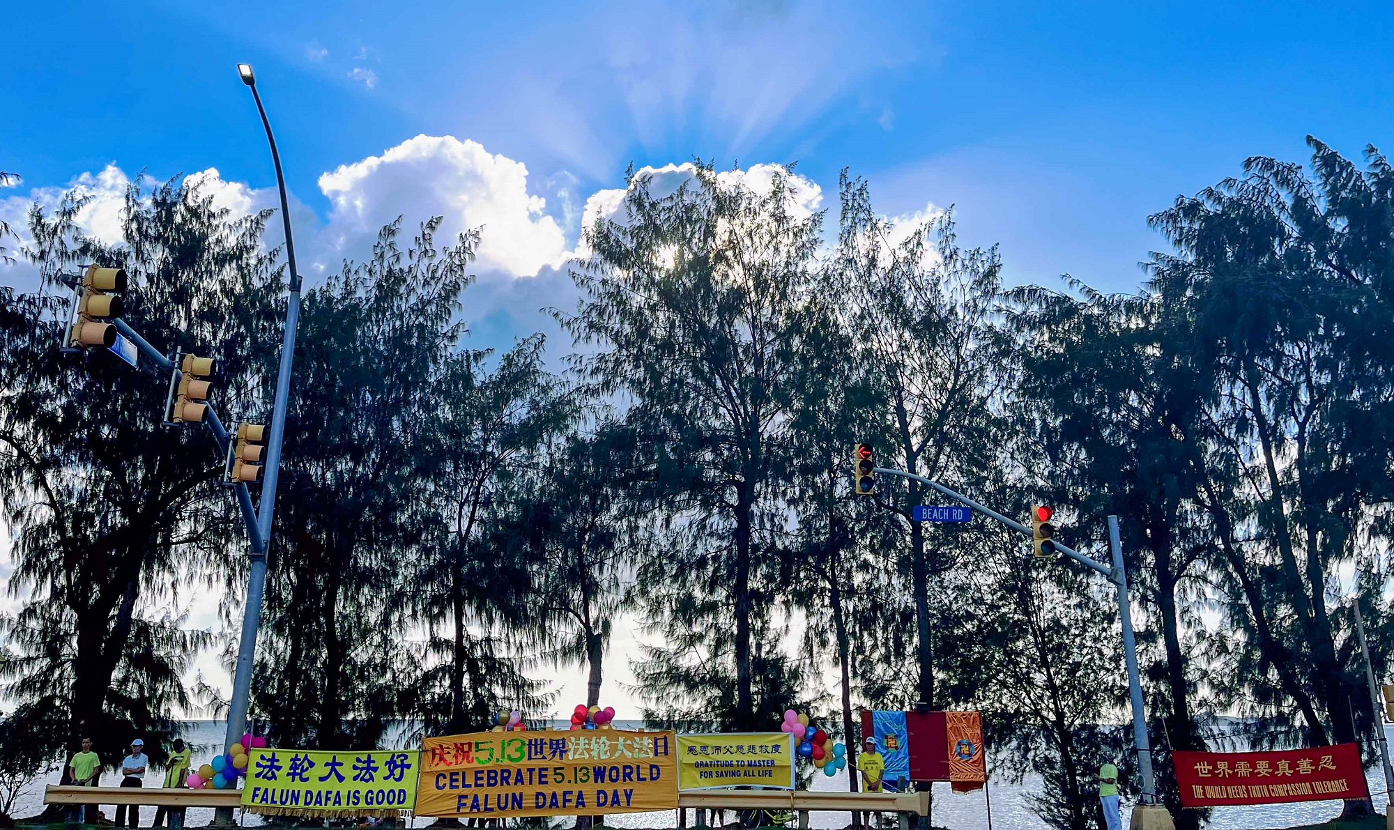 图1:二零二四年五月十三日,法轮功学员在路边展示横幅,传播法轮大法的福音。