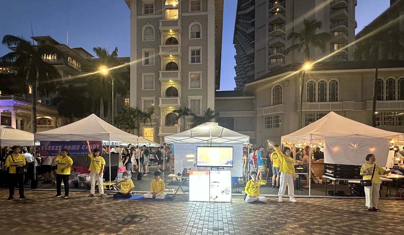 '图1:法轮功学员在夏威夷著名的威基基(Waikiki)景区弘法,征集反迫害签名'