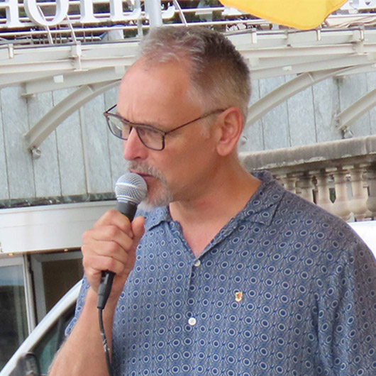 图1:日内瓦州大议会议员塞德里克·让奈雷(Cédric Jeanneret)在现场发言声援法轮功学员。