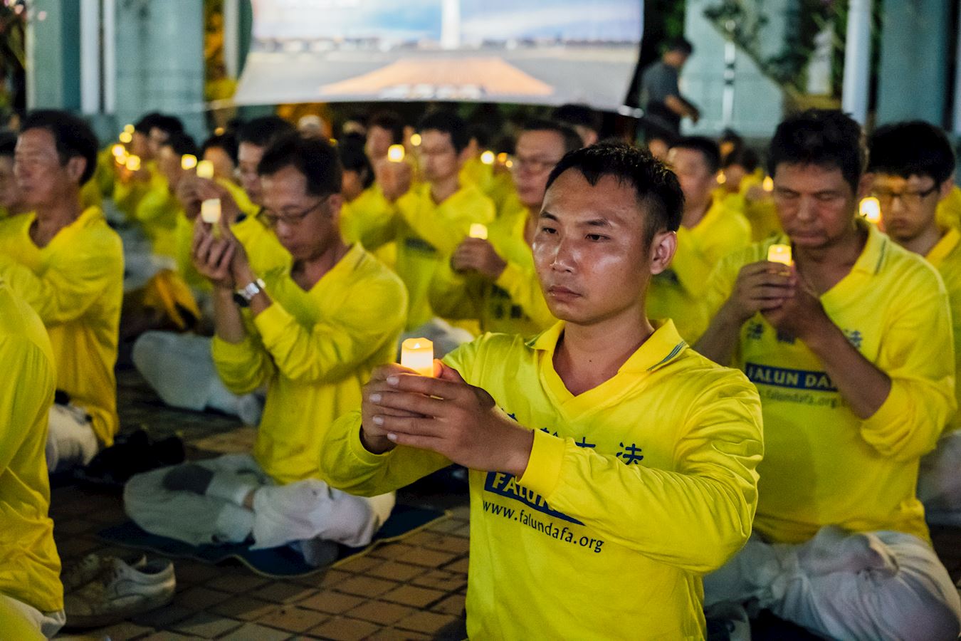 '图8~11:法轮大法学员们点亮手中的烛光,为被迫害致死的法轮大法学员追悼与思念。'