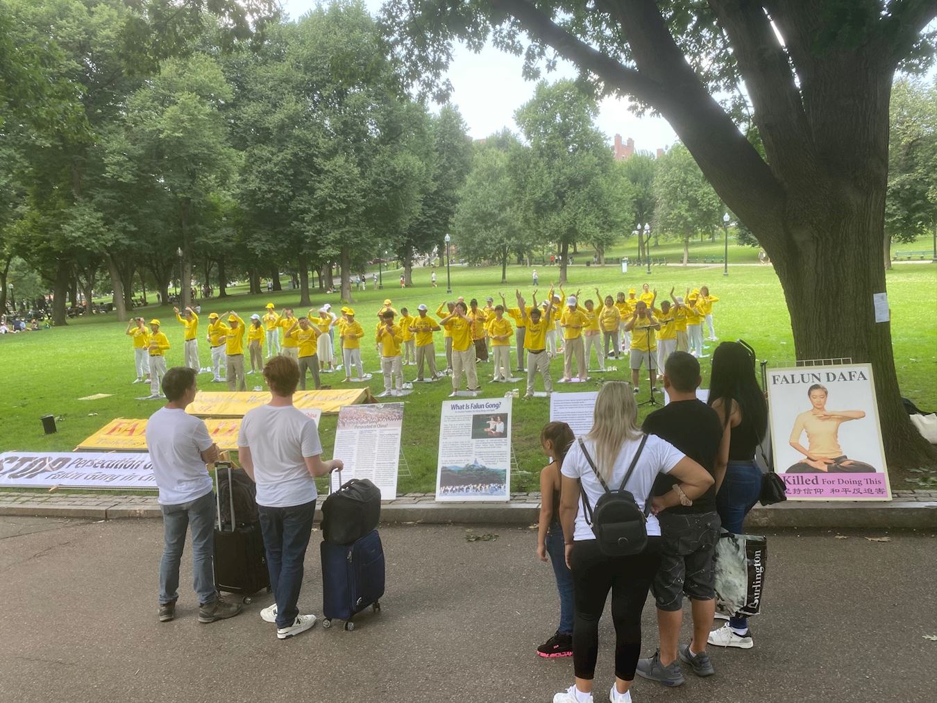 '图1:二零二四年七月十四日,法轮功学员在波士顿公园举行炼功、讲真相活动,图为市民观看真相展板'
