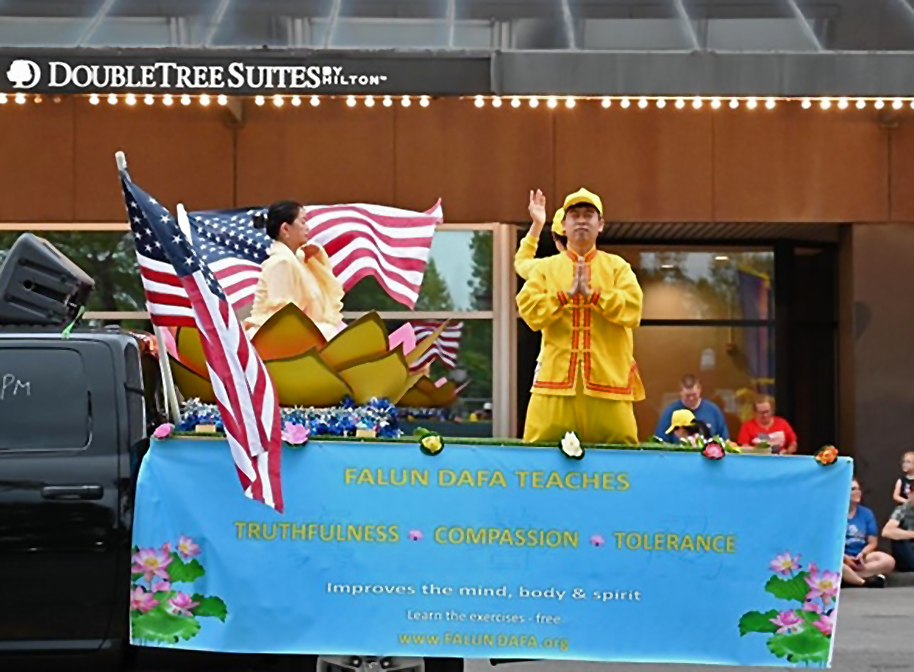 图3:三位学员在花车上向观众演示功法,传递法轮大法的美好。