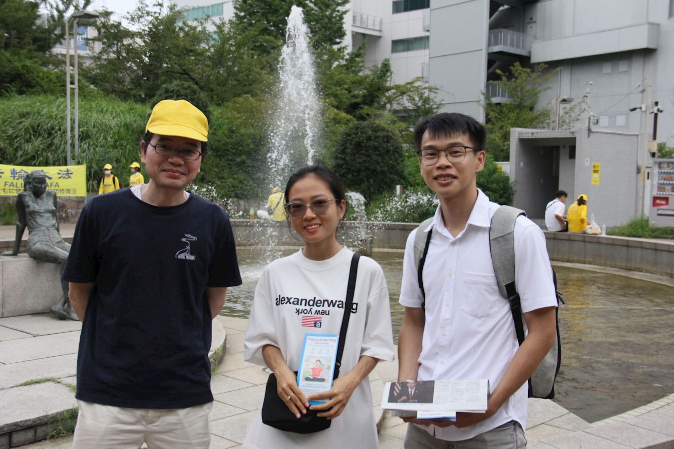 '图12:越南游客阮先生(右一)对学炼法轮功感兴趣'
