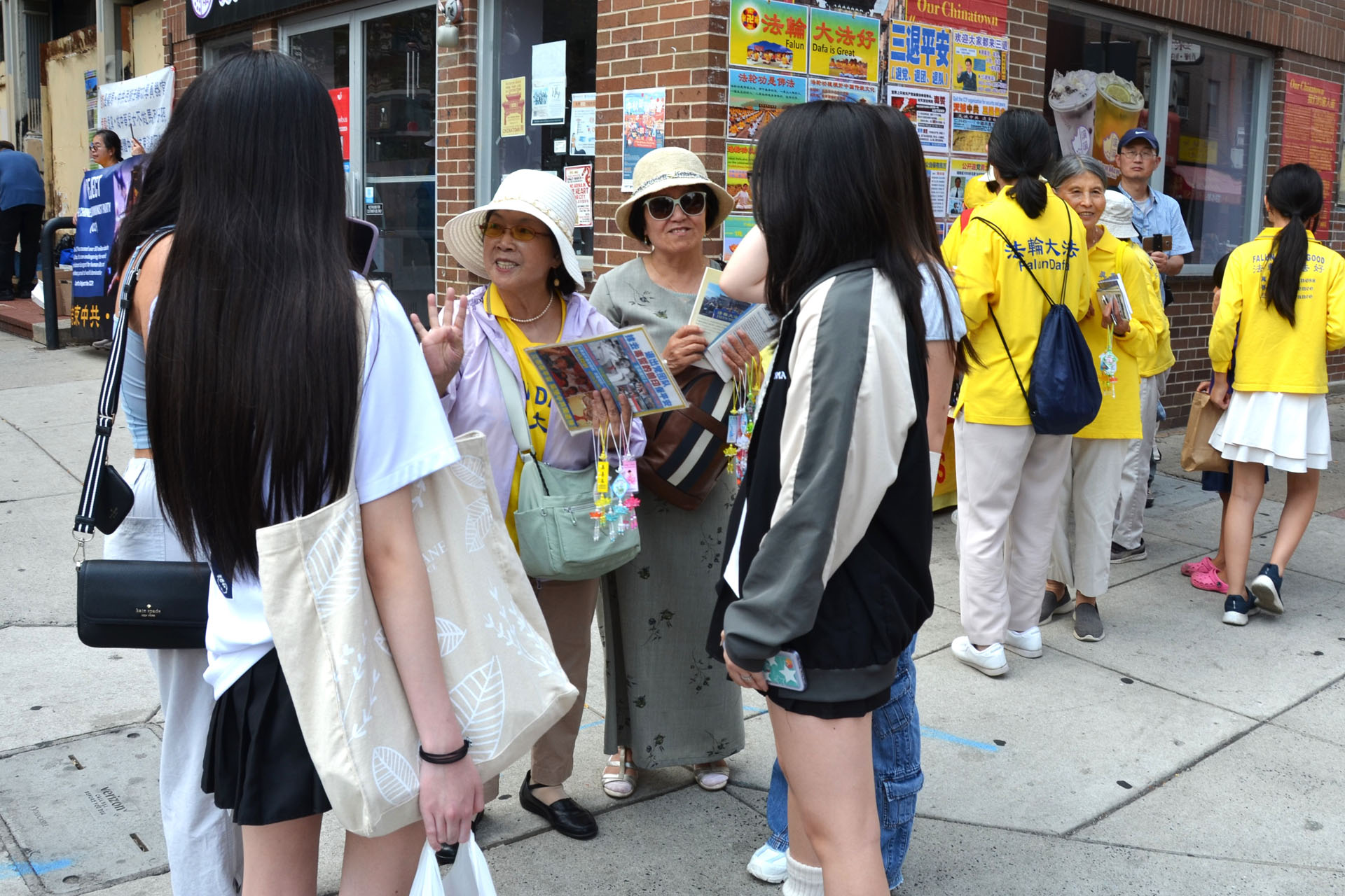 图7~10:法轮功学员在费城唐人街集会期间向路人揭露中共活摘法轮功学员器官的罪行。