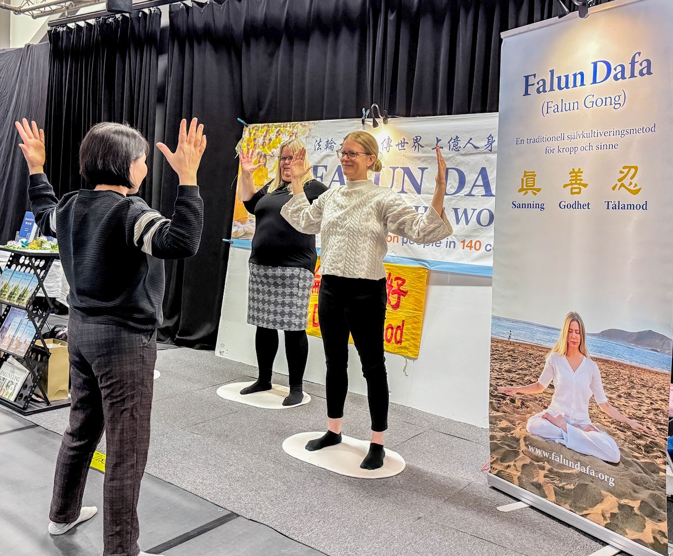 '图4:人们得知有瑞典语网上免费教功班时,纷纷踊跃报名,有人当场学功体验炼功动作。'