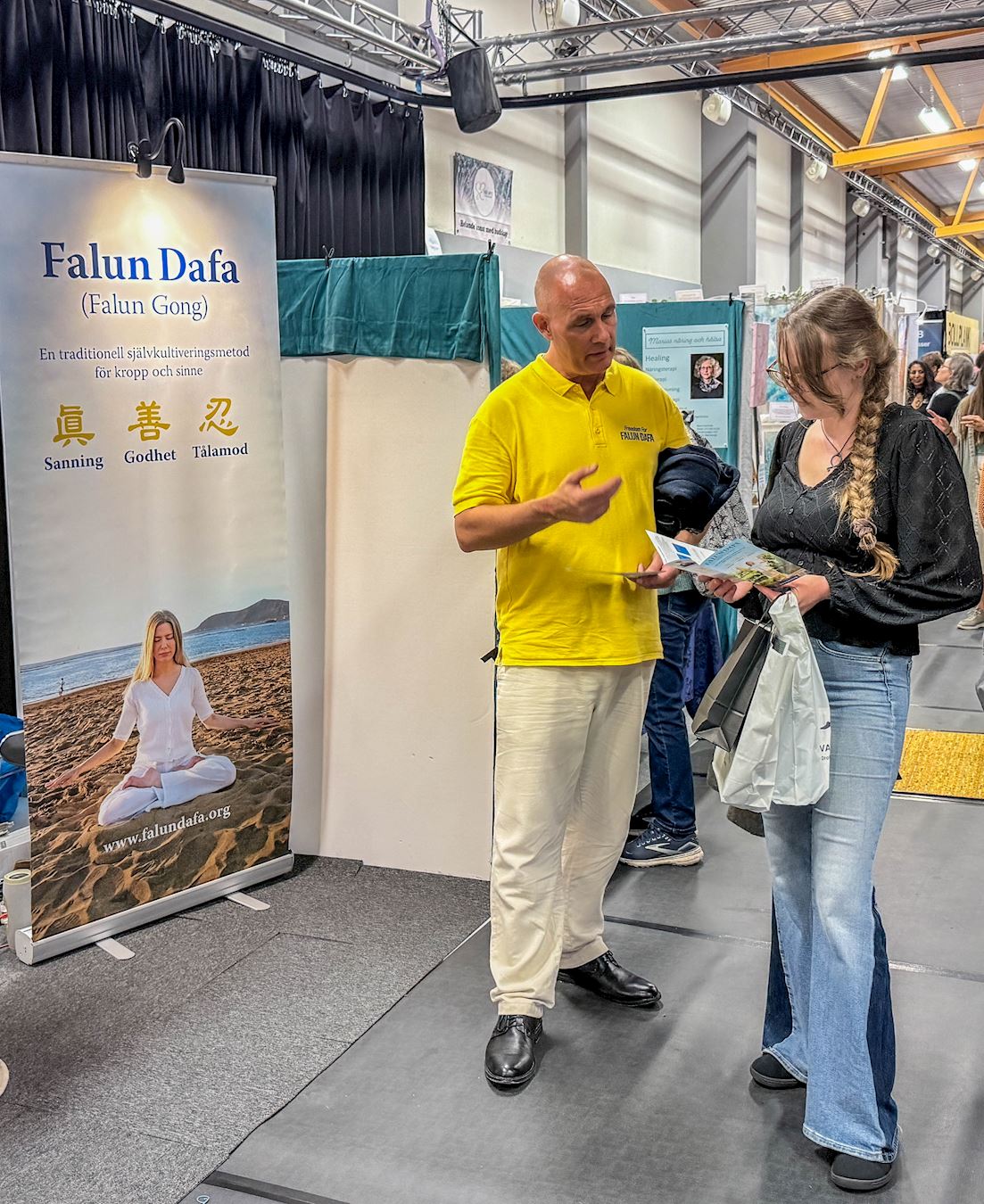 '图5~7:在现场很多人询问许多有关法轮功的详情,并表示对功法感兴趣。学员耐心地做解答。'