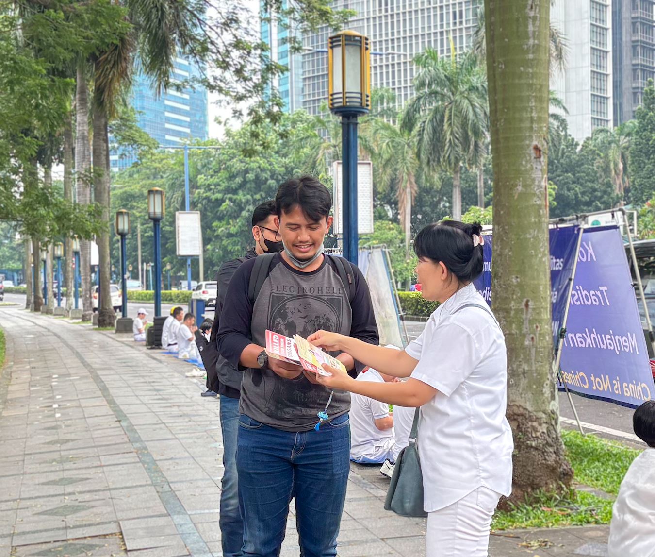 '图2:路人在集会现场了解法轮大法及被中共迫害的真相。'