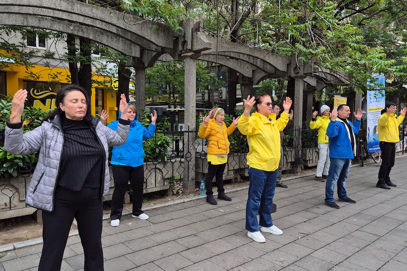 '图2~3:五月十日,罗马尼亚学员在罗马广场举办信息日活动,他们演示法轮功功法,并征集签名,呼吁停止迫害法轮功。'