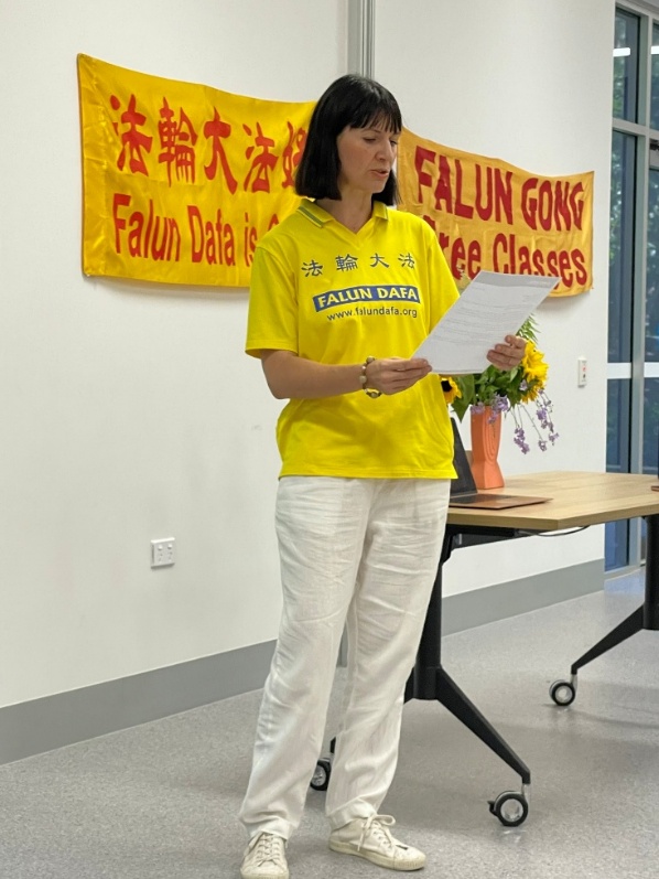 图3:一位法轮功学员宣读昆士兰州议员布里·詹姆斯(Bree James)的支持信。